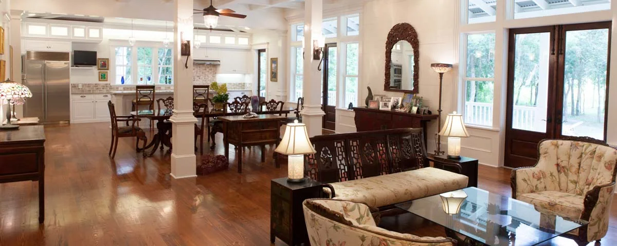 Open great room and dining area with heart-pine floors, white trim and French doors to the porch