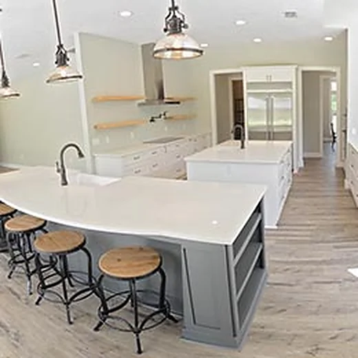Bright kitchen with a curved white island, wood bar stools, pendant lights and open shelving